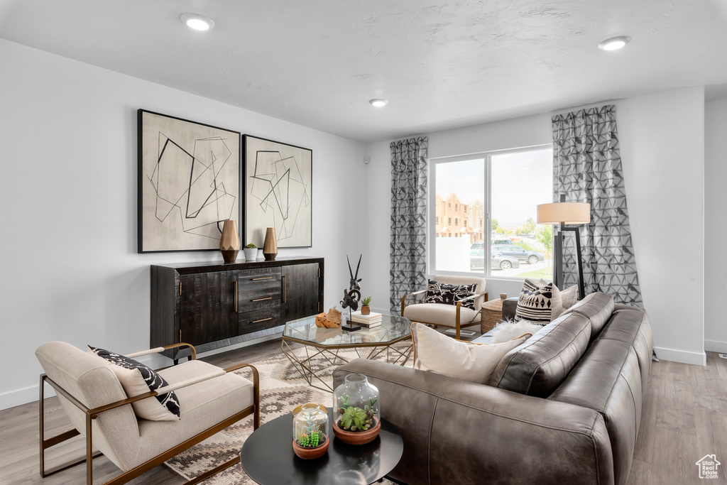 Living room featuring recessed lighting, baseboards, and light wood-type flooring