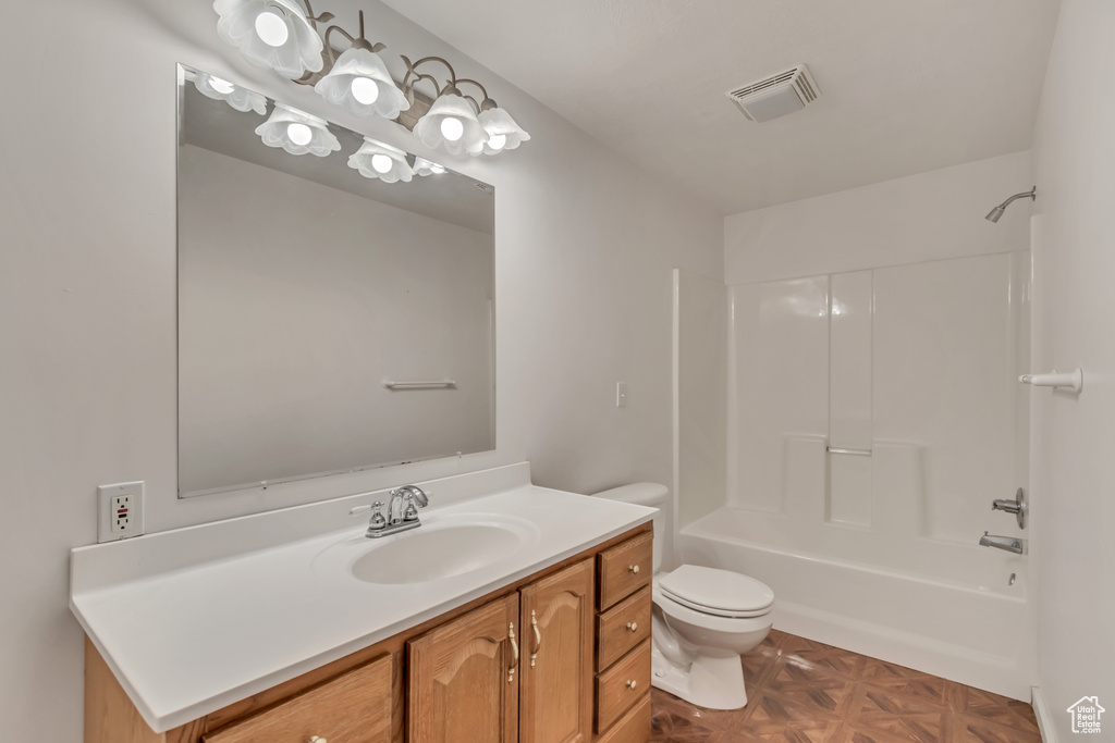 Bathroom with toilet, vanity, bathtub / shower combination, and visible vents