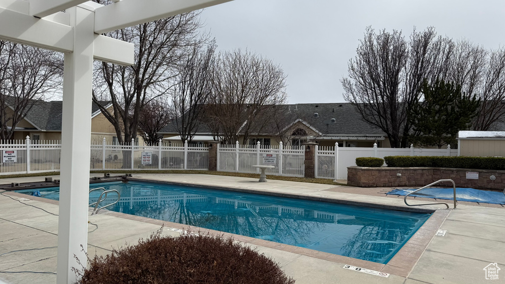 Community pool featuring a patio and fence
