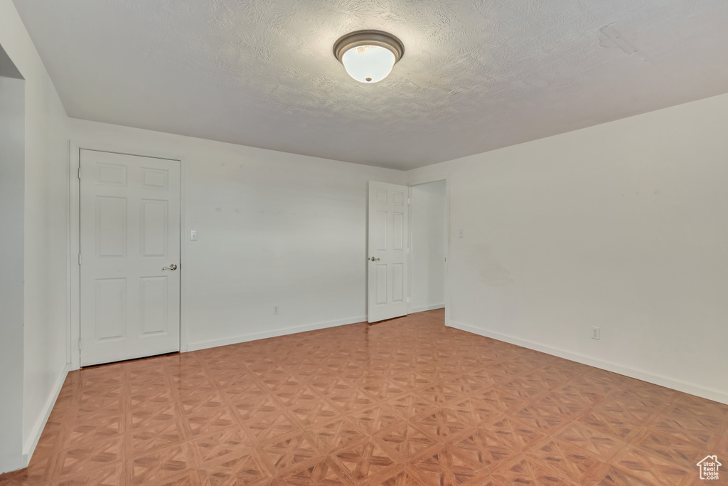 Unfurnished room with baseboards and a textured ceiling