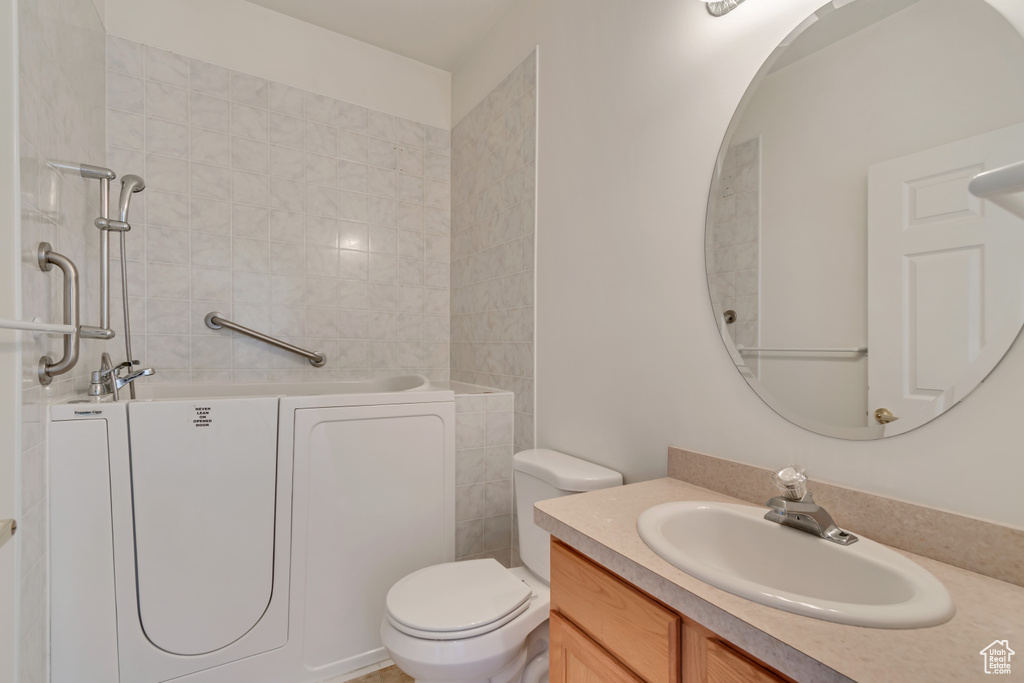 Bathroom featuring a bath, toilet, and vanity