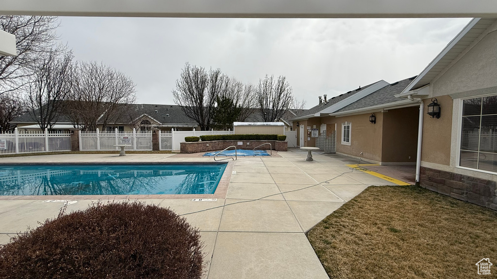 Pool with a patio and fence