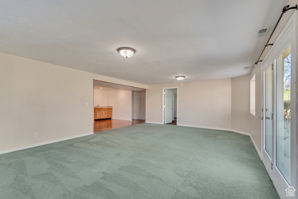 Carpeted spare room with baseboards and visible vents
