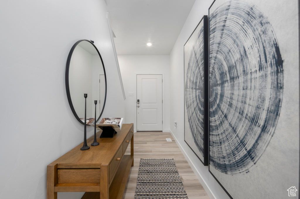 Corridor featuring baseboards and light wood-style flooring