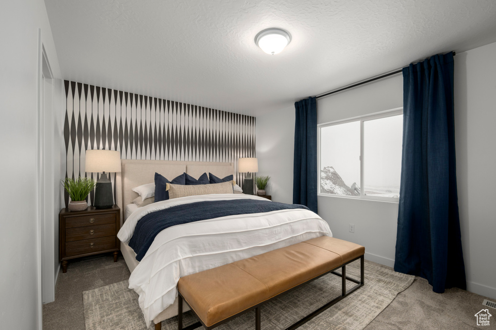 Bedroom with baseboards, carpet flooring, and a textured ceiling