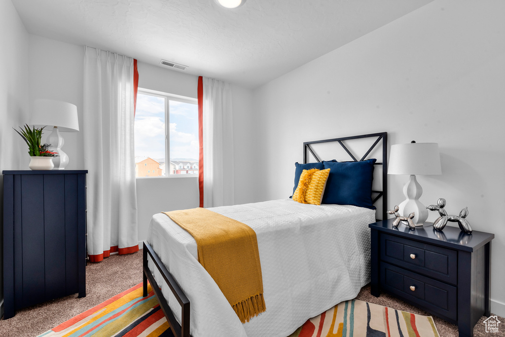 Bedroom with baseboards, visible vents, and carpet