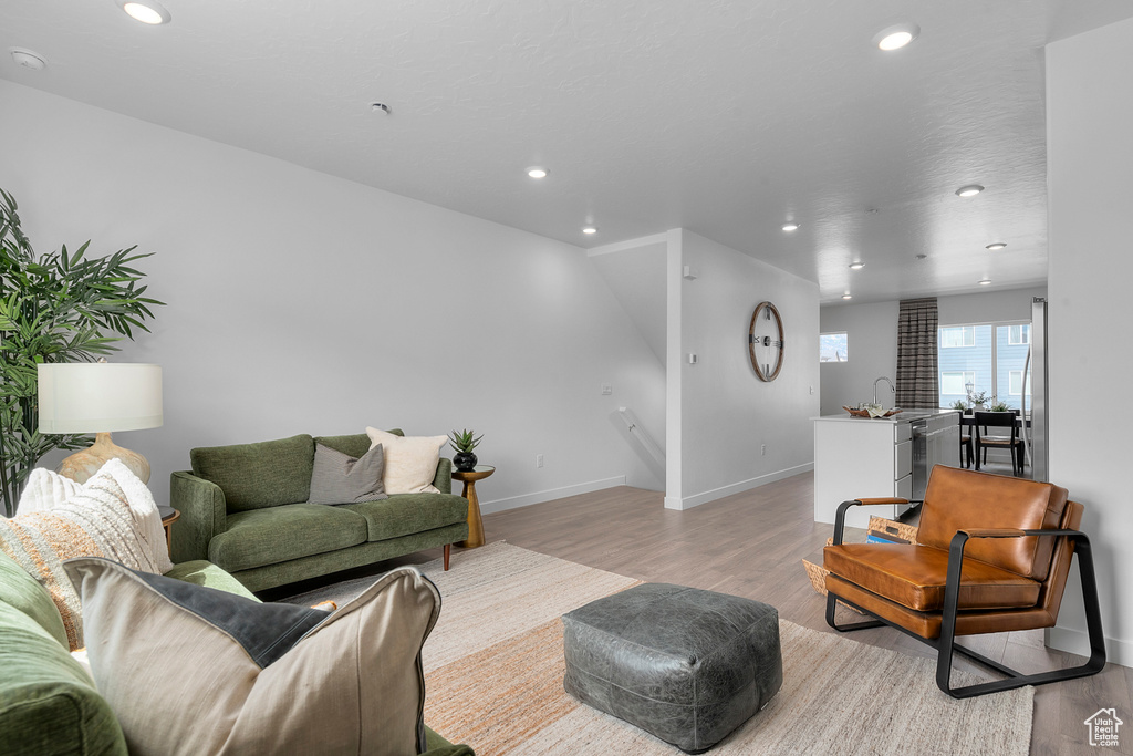 Living room with recessed lighting, baseboards, and light wood-type flooring