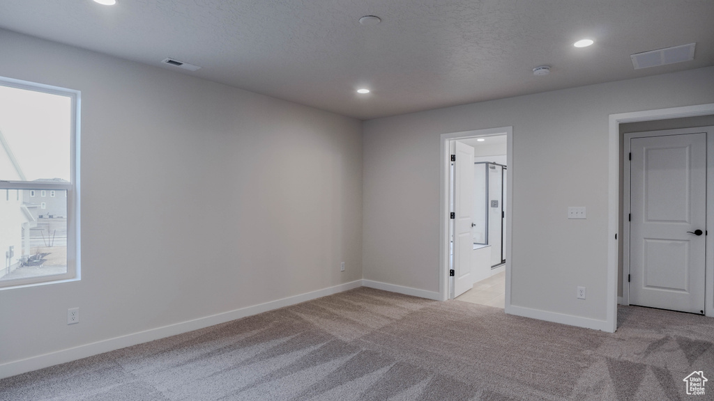 Unfurnished room with recessed lighting, baseboards, light colored carpet, and visible vents
