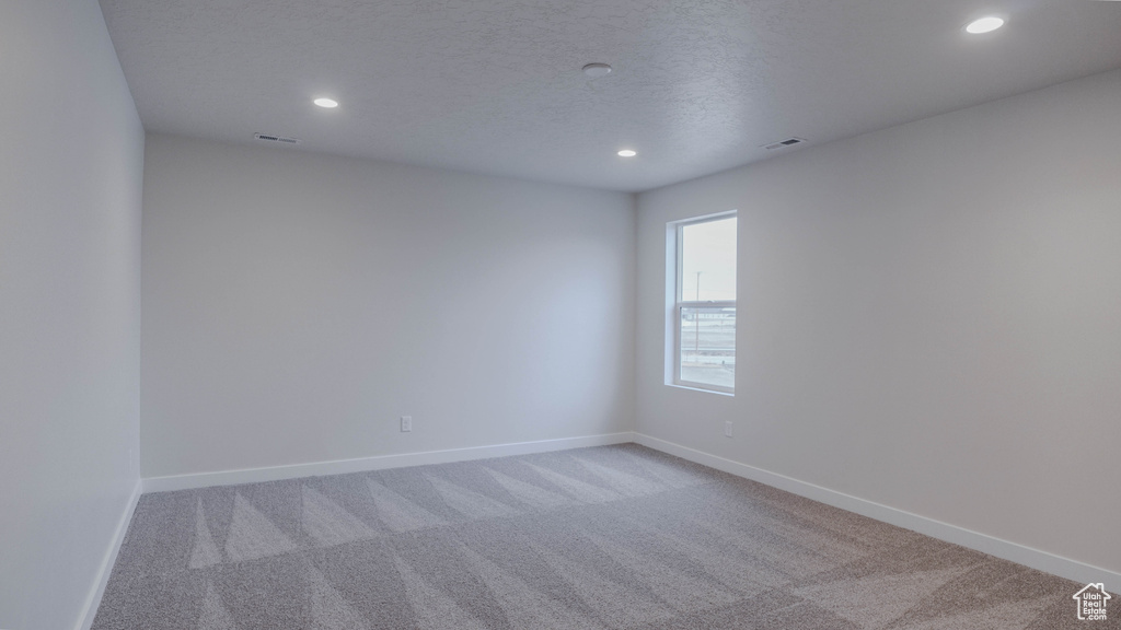 Unfurnished room with baseboards, visible vents, recessed lighting, and light colored carpet