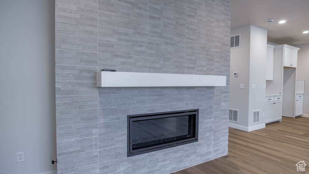 Room details with wood finished floors, a fireplace, and visible vents