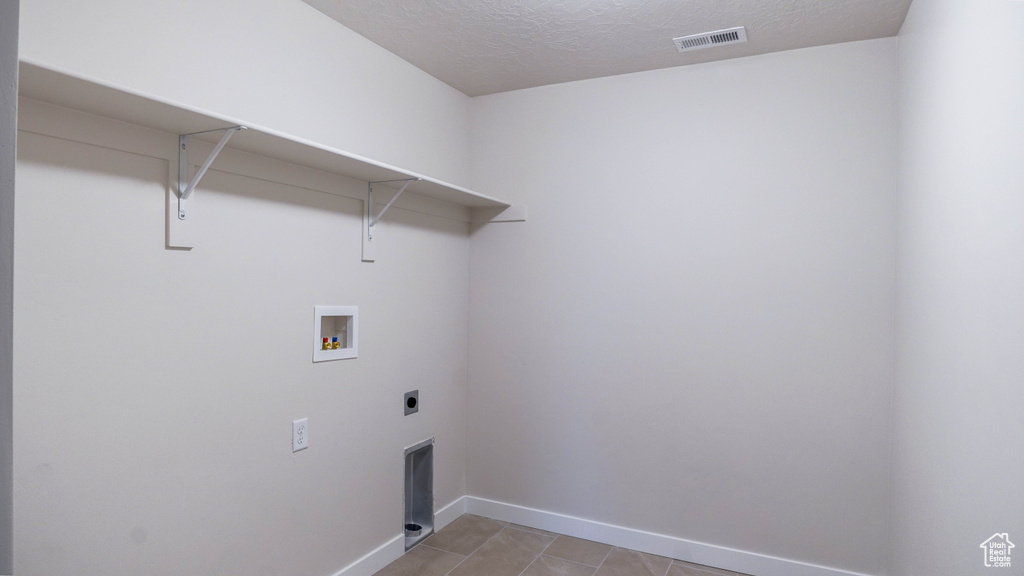Laundry area with hookup for an electric dryer, hookup for a washing machine, baseboards, visible vents, and laundry area