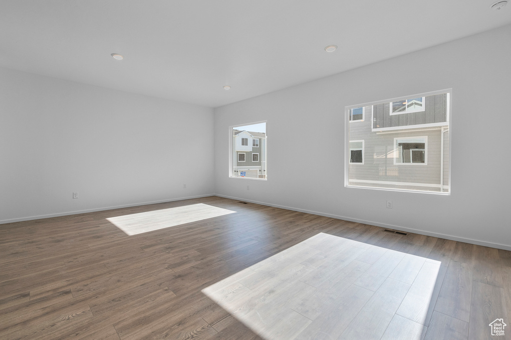 Spare room featuring baseboards, visible vents, and wood finished floors