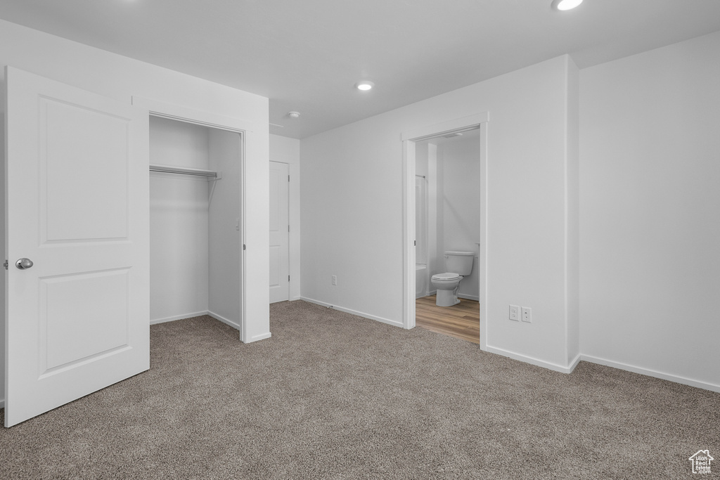 Unfurnished bedroom featuring recessed lighting, carpet flooring, baseboards, connected bathroom, and a closet