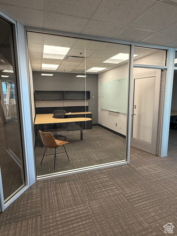 Unfurnished office with baseboards, carpet, and a paneled ceiling
