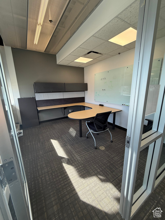 Carpeted office featuring baseboards and a paneled ceiling