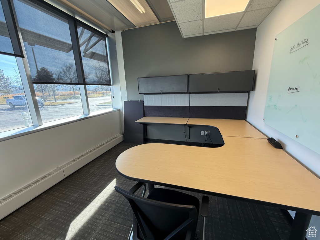 Office featuring a baseboard radiator, dark carpet, and a paneled ceiling