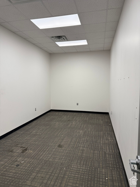 Empty room featuring carpet flooring, a paneled ceiling, baseboards, and visible vents