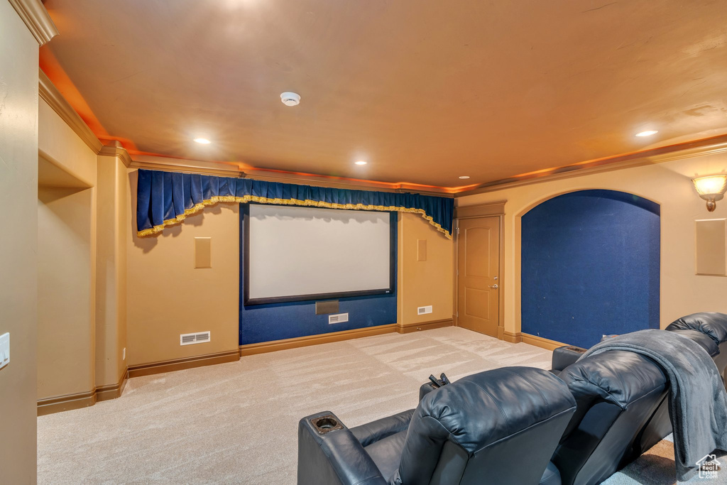 Carpeted cinema with baseboards, arched walkways, visible vents, and recessed lighting