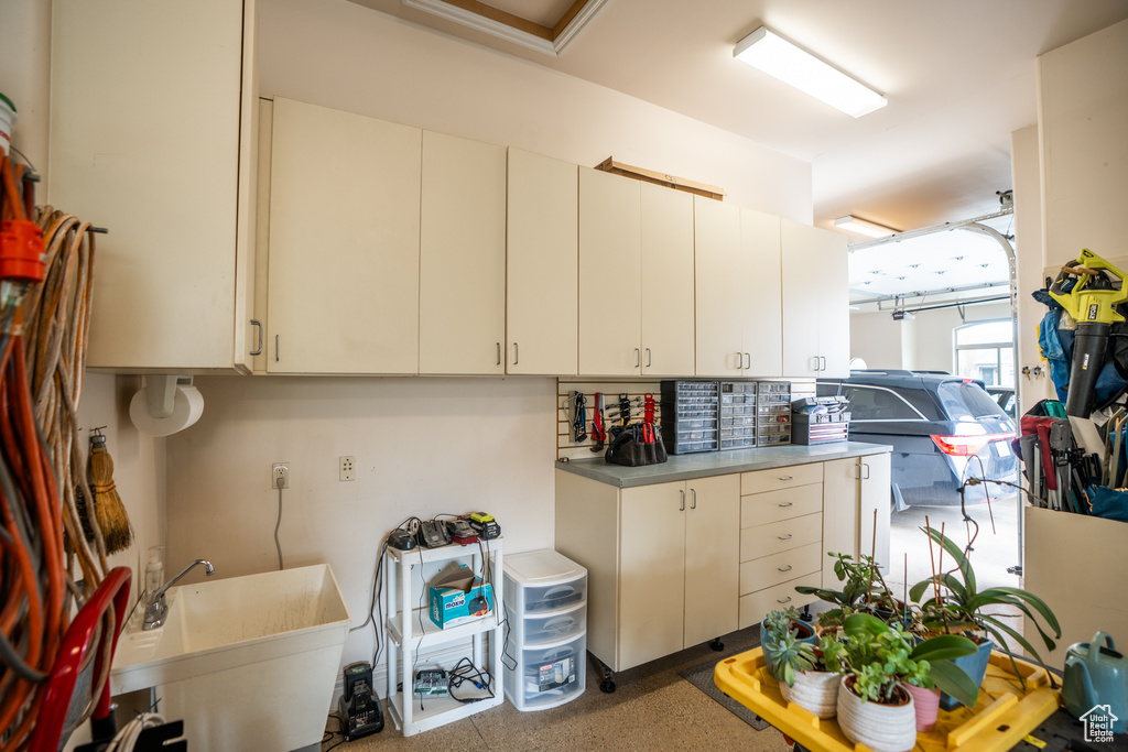 Kitchen featuring backsplash, light countertops, a sink, and cream cabinetry
