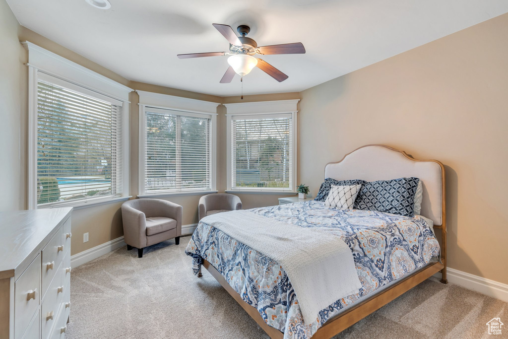 Bedroom with baseboards, ceiling fan, and light carpet