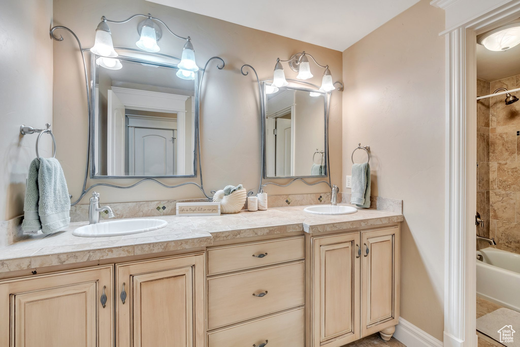 Full bath featuring double vanity, a sink, and shower / bathing tub combination