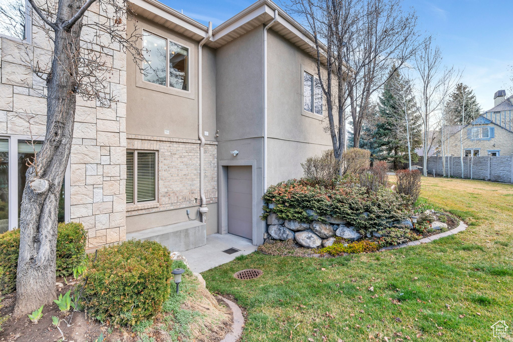 View of front of property with stucco siding, fence, and a front lawn