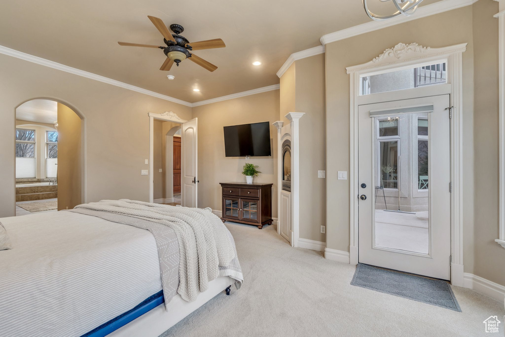 Bedroom with baseboards, ornamental molding, recessed lighting, light carpet, and arched walkways