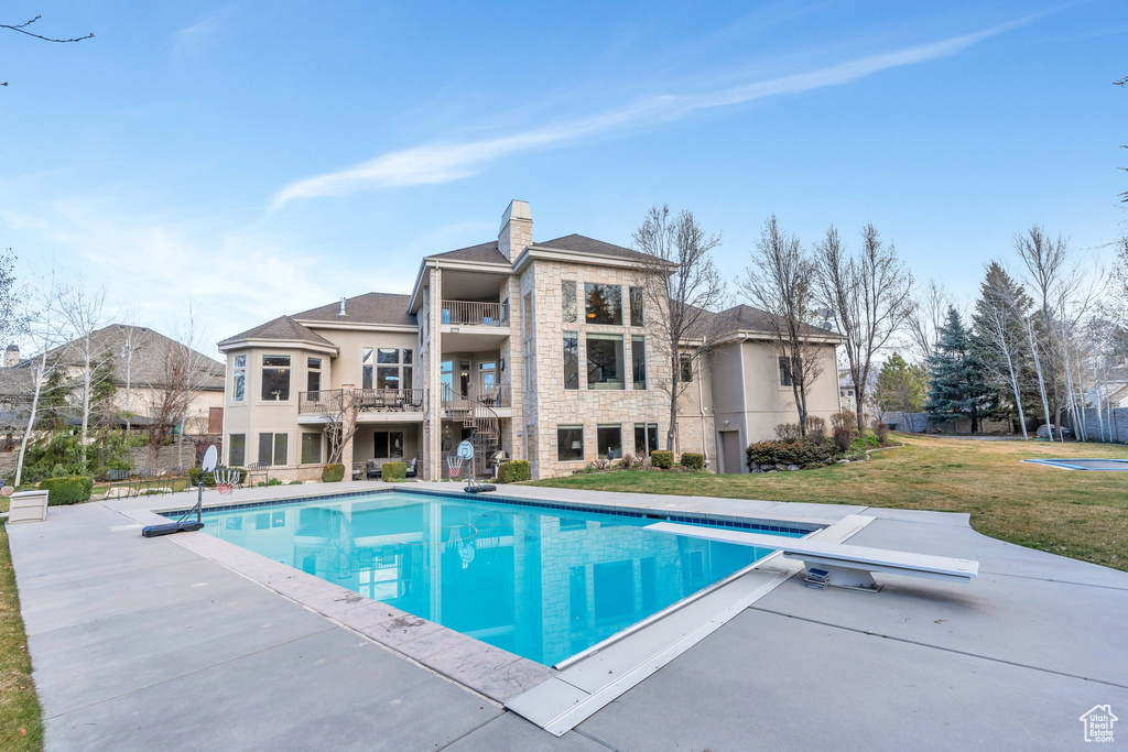Outdoor pool featuring a patio area and a lawn