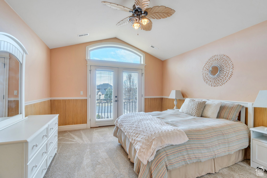 Bedroom with a wainscoted wall, access to exterior, french doors, light colored carpet, and visible vents