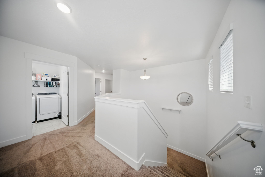Interior space featuring carpet flooring, washing machine and clothes dryer, and baseboards