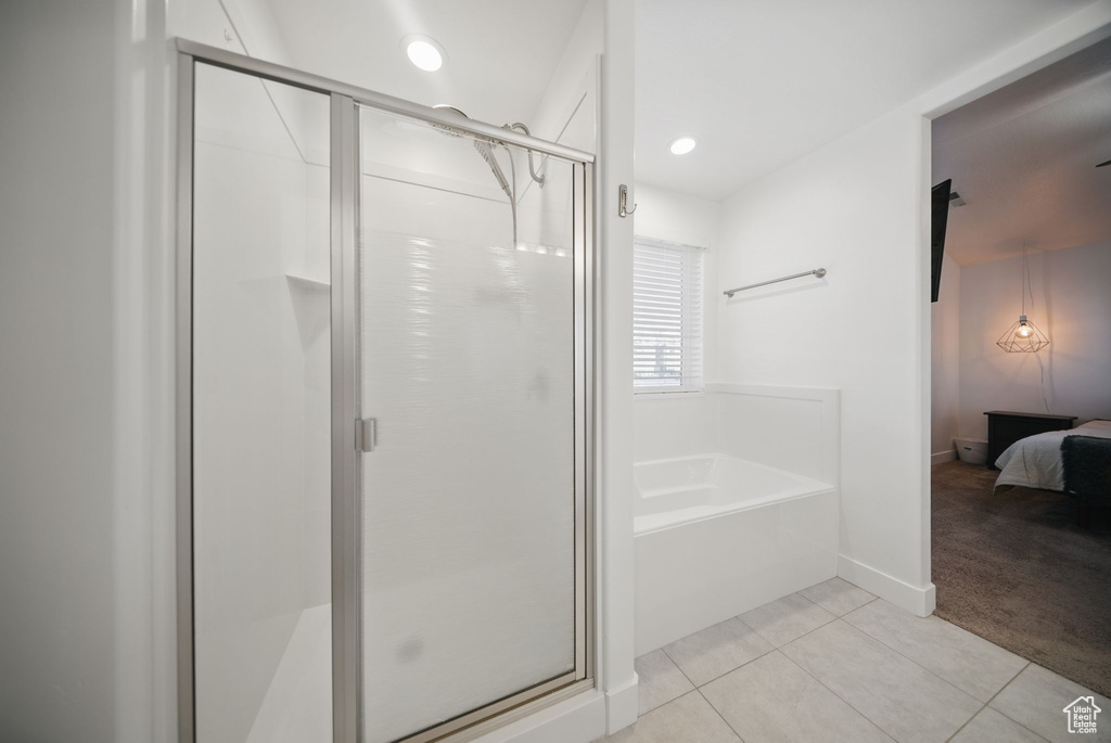 Ensuite bathroom featuring a bath, baseboards, tile patterned floors, a stall shower, and ensuite bath