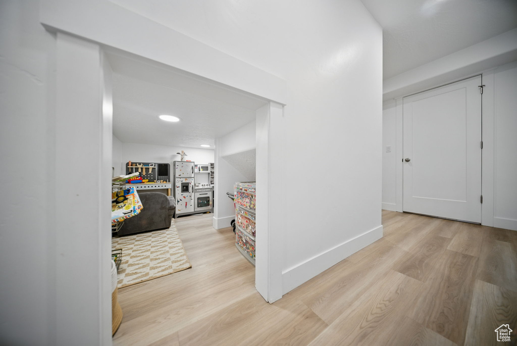 Corridor with baseboards and light wood-style floors