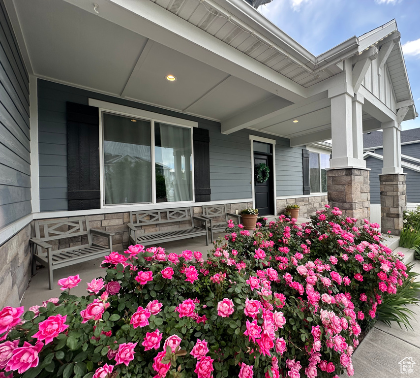 Entrance to property with a porch and stone siding