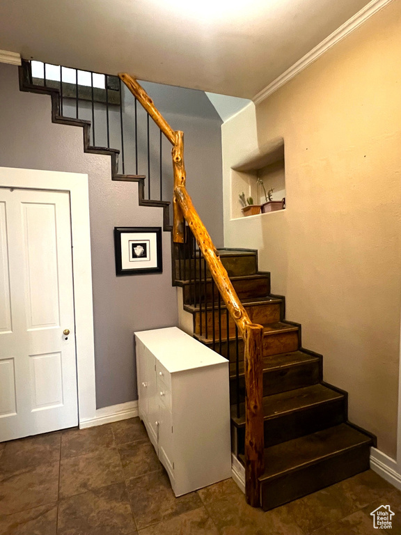 Stairs featuring baseboards and ornamental molding