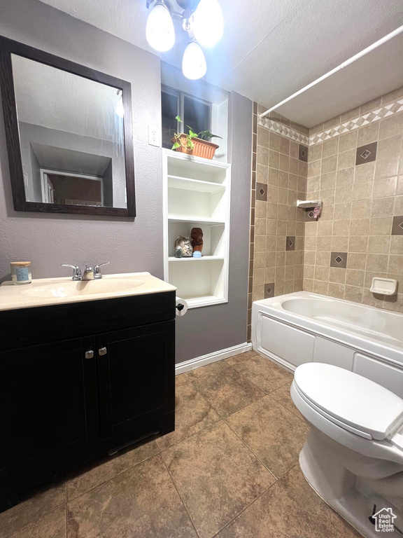 Bathroom with built in shelves, washtub / shower combination, toilet, vanity, and a textured ceiling