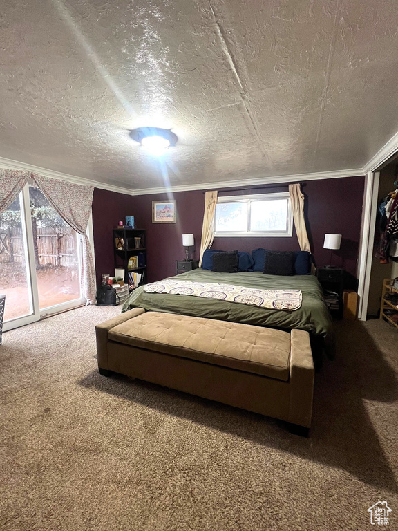 Bedroom with a textured ceiling, carpet, and ornamental molding