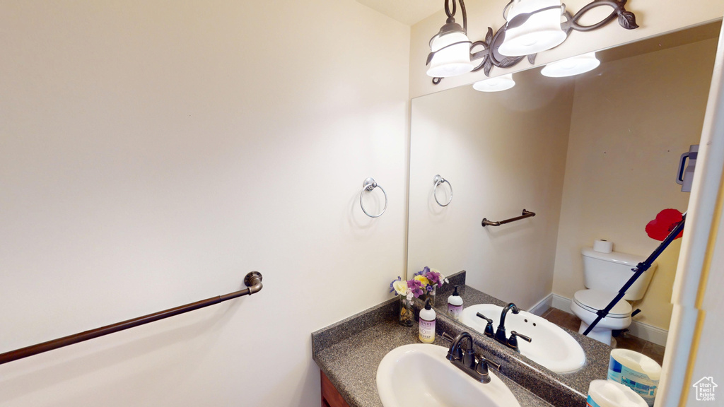 Half bathroom featuring vanity and a chandelier