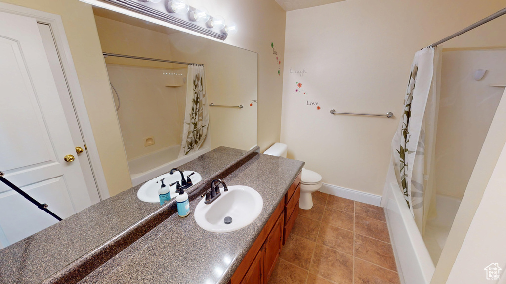 Bathroom with vanity, shower / tub combo with curtain, and tile patterned flooring