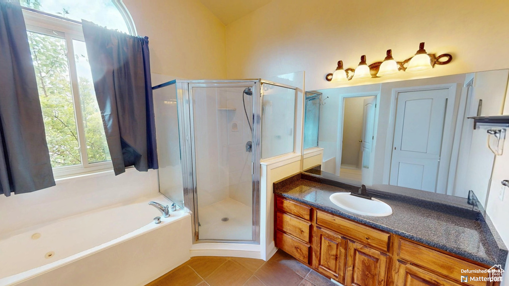 Full bathroom featuring a stall shower, vanity, healthy amount of natural light, and a garden tub