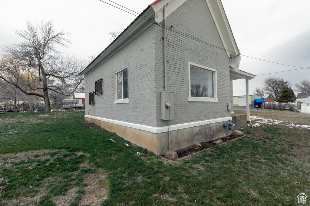 View of home's exterior with a lawn and brick siding