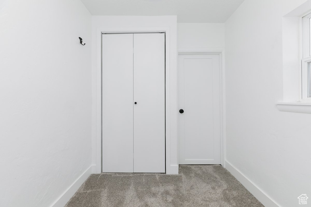 Unfurnished bedroom featuring a closet, carpet floors, and baseboards