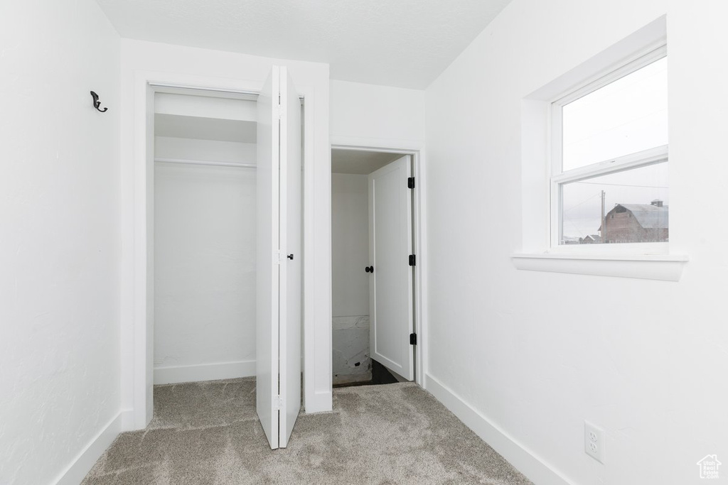 Unfurnished bedroom featuring baseboards, a closet, and carpet flooring