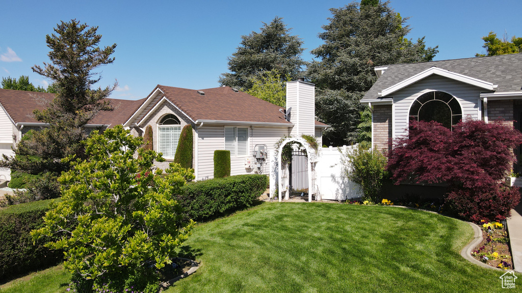 View of front of house with a shingled roof and a chimney