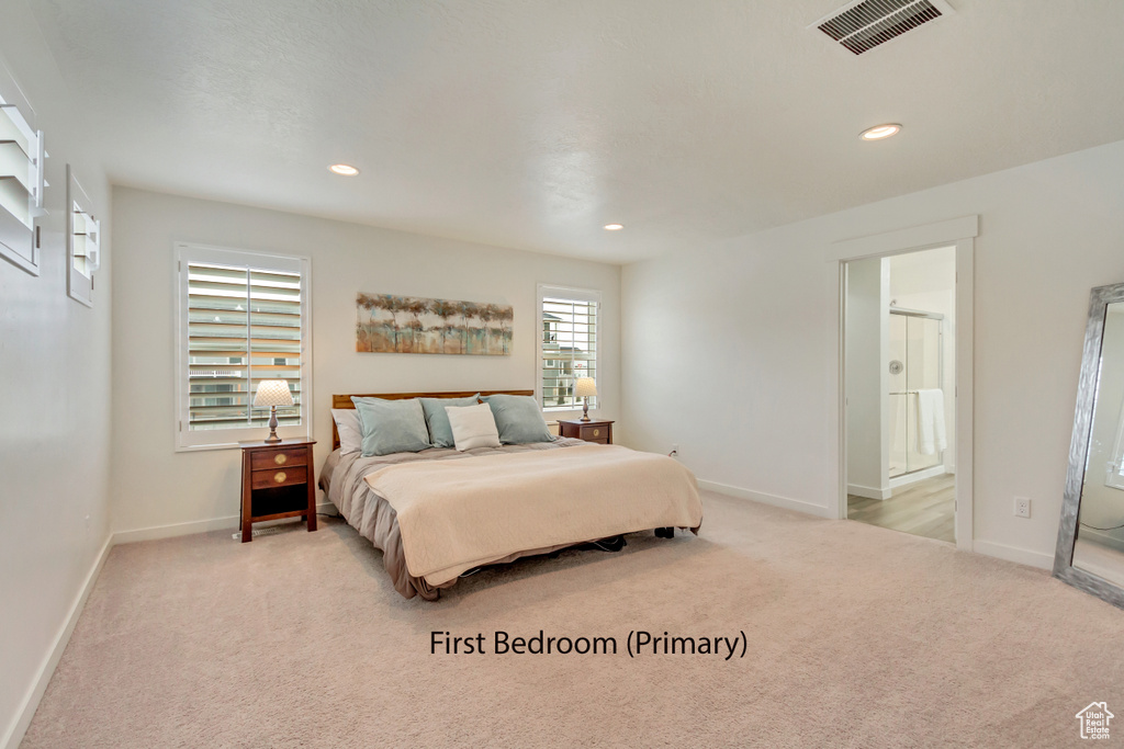 Carpeted bedroom featuring baseboards, recessed lighting, and connected bathroom