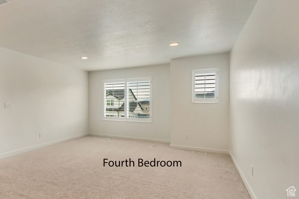 Unfurnished room with plenty of natural light, light colored carpet, baseboards, and recessed lighting