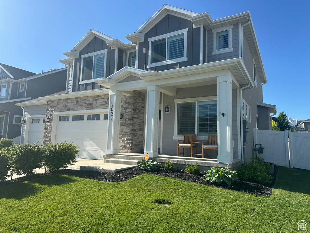 View of front facade with a porch, board and batten siding, and an attached garage