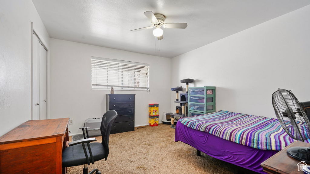 Bedroom with a closet, a ceiling fan, baseboards, and carpet