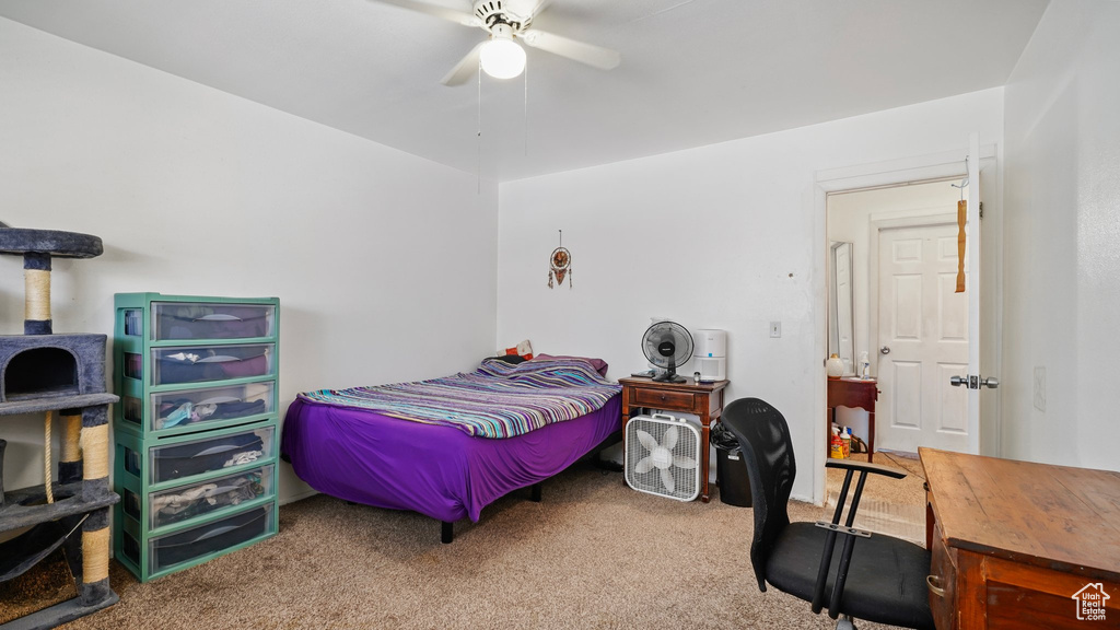 Carpeted bedroom featuring a ceiling fan