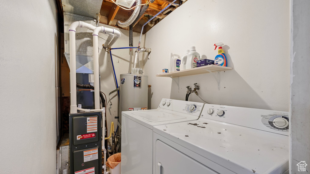 Clothes washing area with laundry area, gas water heater, and separate washer and dryer