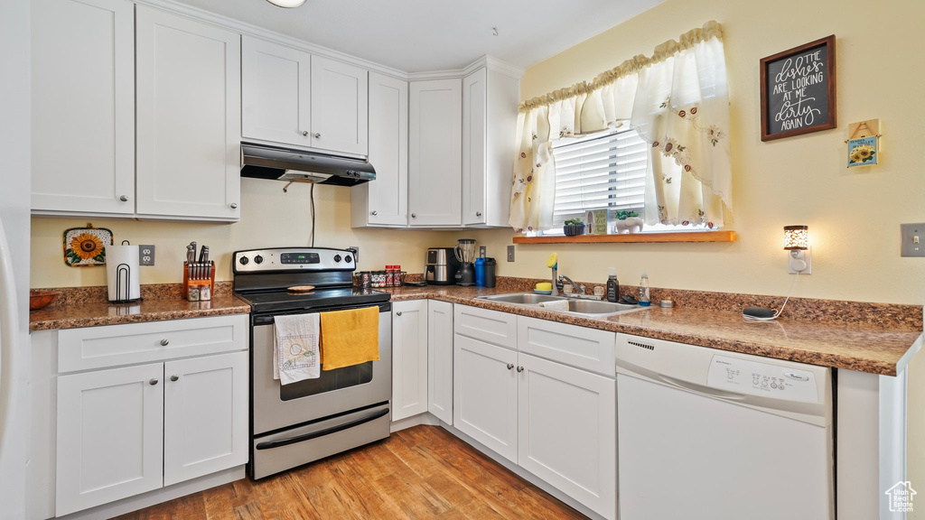 Kitchen with white cabinetry, under cabinet range hood, stainless steel electric stove, a sink, and dishwasher